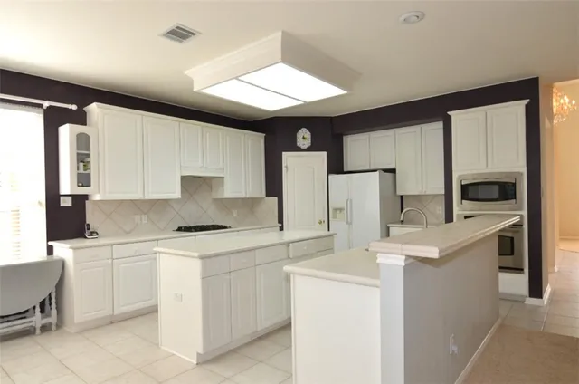 a kitchen with a sink a stove a refrigerator and cabinets