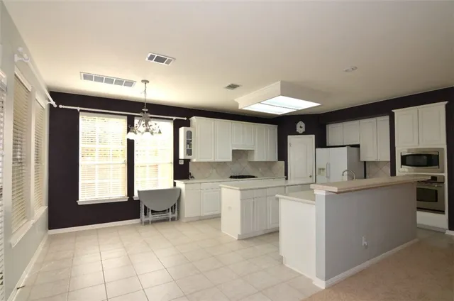 a kitchen with a sink appliances and cabinets