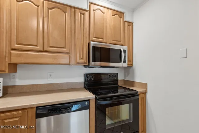 a kitchen with granite countertop a stove sink and microwave