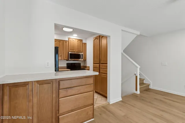 an empty room with wooden floor and a ceiling fan