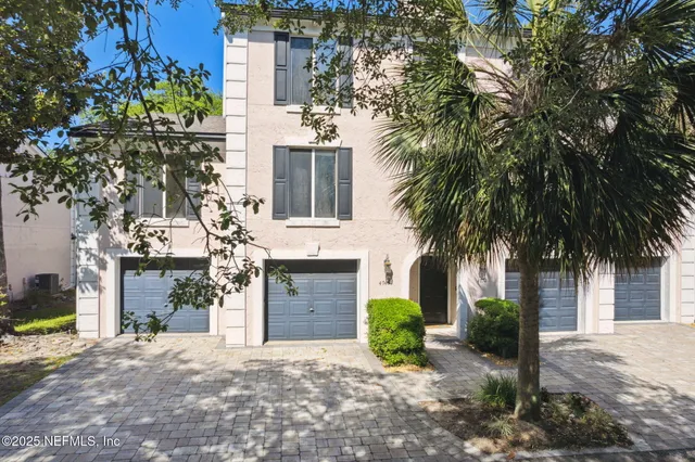 an aerial view of residential houses with outdoor space and trees
