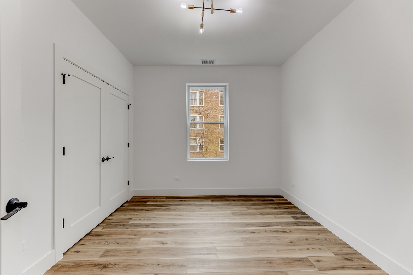 5921 South Calumet Avenue, Unit 2 Chicago, IL 60637 - Photo 13 of 40 a view of empty room with wooden floor and fan