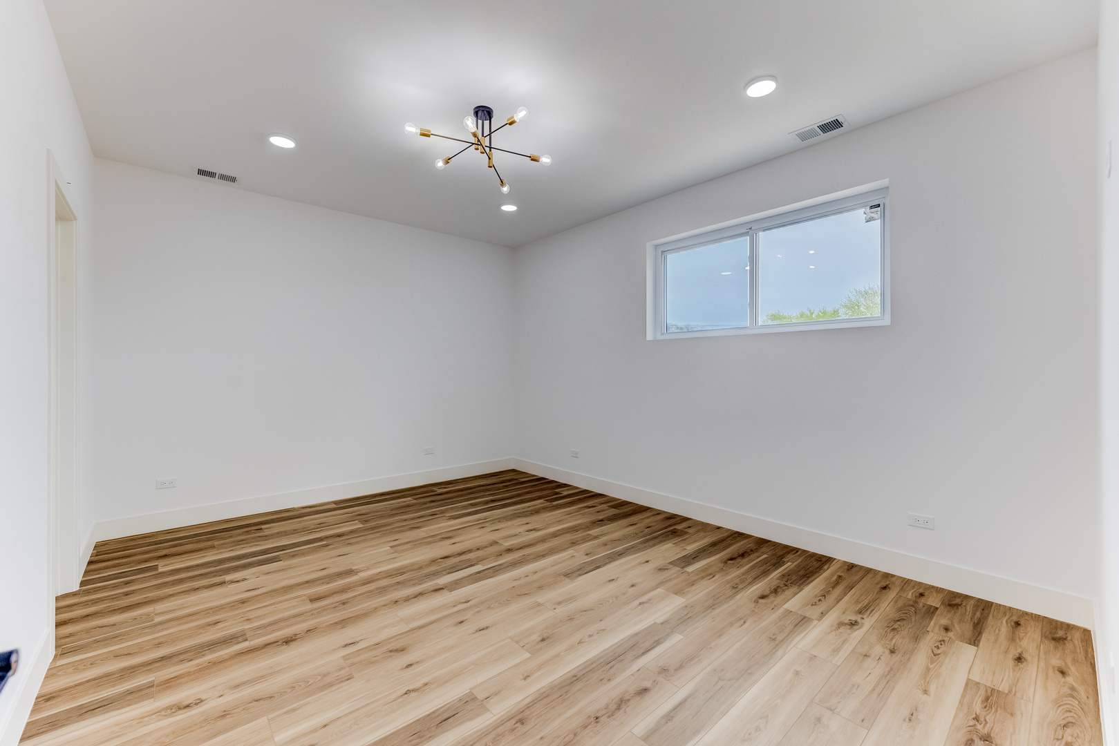 5921 South Calumet Avenue, Unit 2 Chicago, IL 60637 - Photo 25 of 40 an empty room with wooden floor and chandelier fan