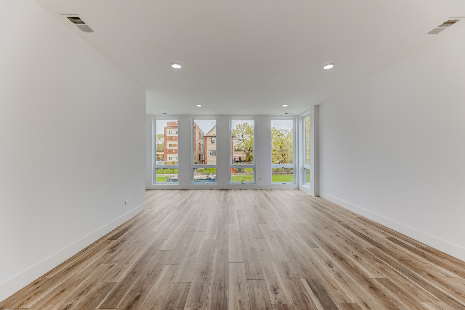 5921 South Calumet Avenue, Unit 2 Chicago, IL 60637 - Photo 8 of 40 a view of an empty room with a window and wooden floor