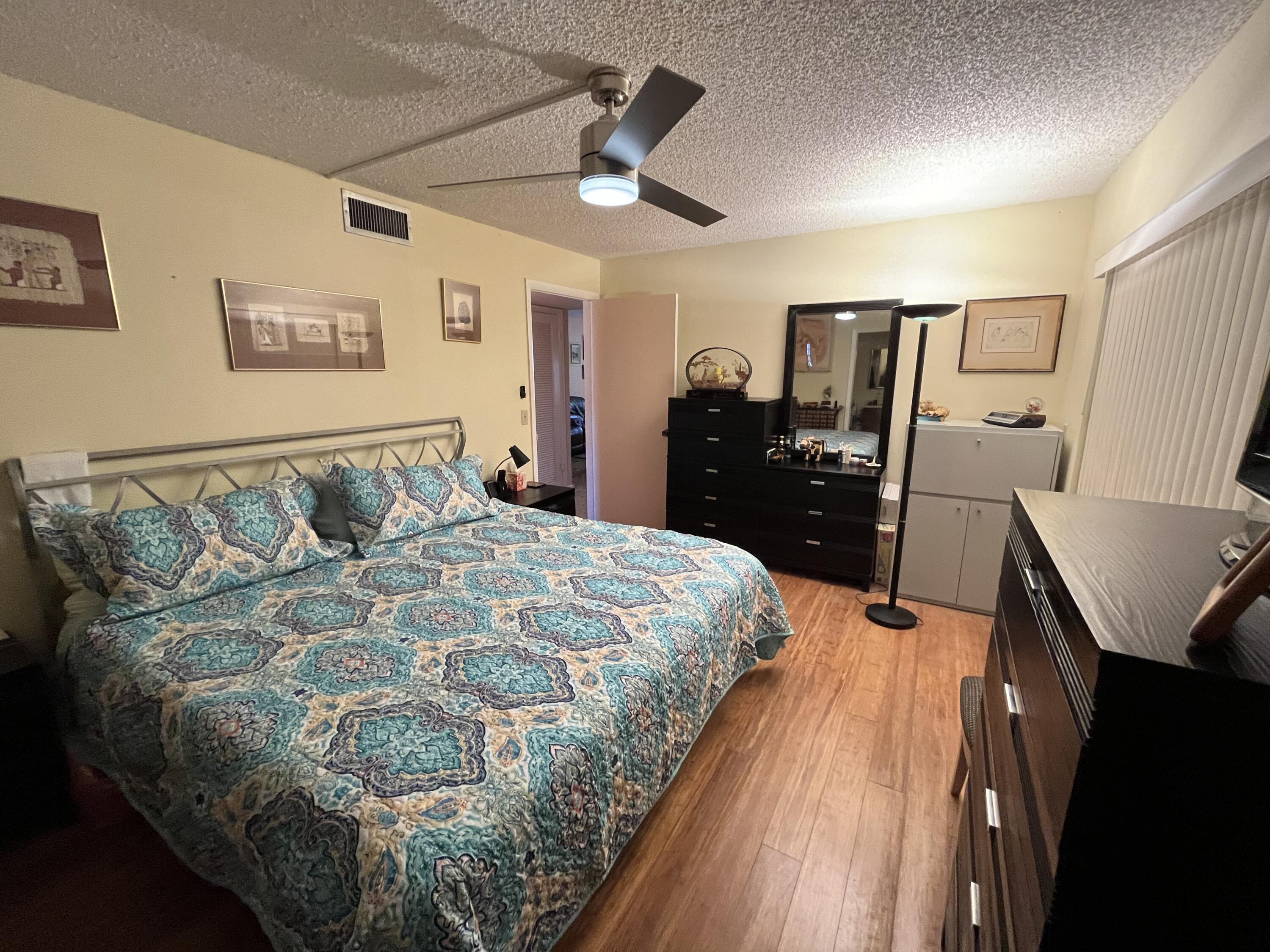 114 Capri B Delray Beach, FL 33484 - Photo 18 of 21 a bed sitting in a bedroom next to a window with pc on the table