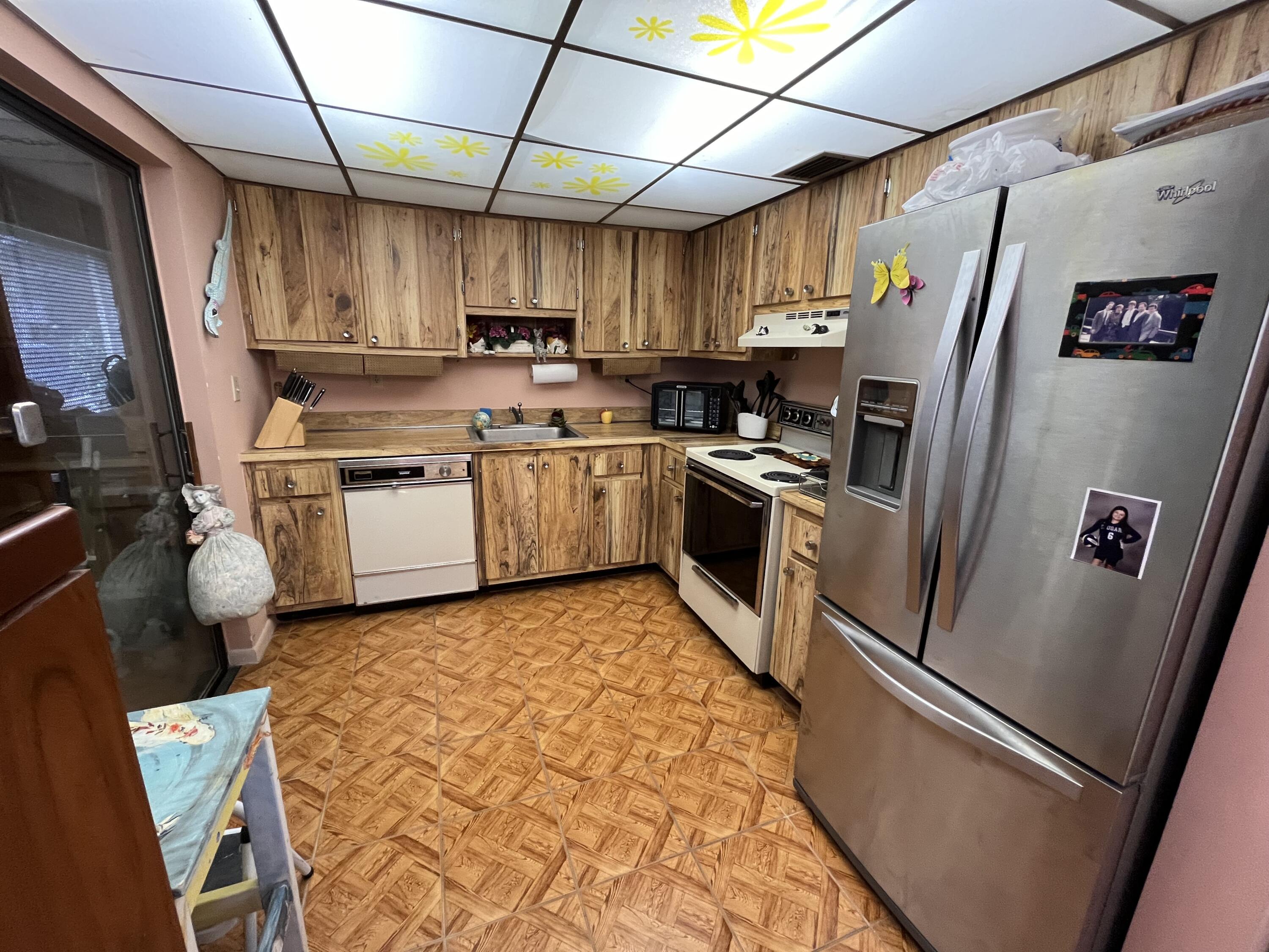 114 Capri B Delray Beach, FL 33484 - Photo 6 of 21 a kitchen with stainless steel appliances granite countertop a refrigerator a stove top oven a sink and dishwasher