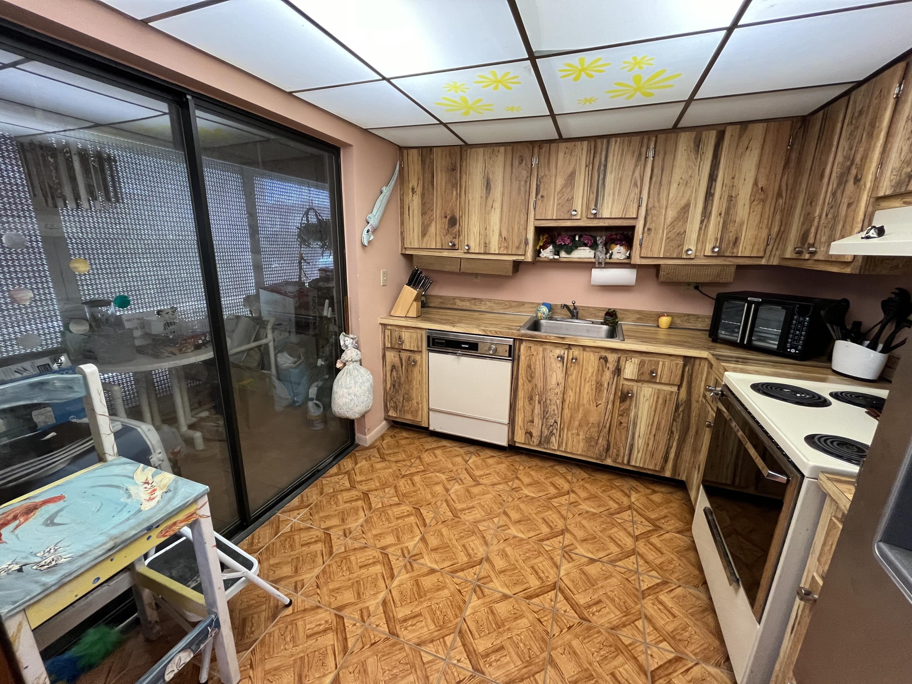 114 Capri B Delray Beach, FL 33484 - Photo 7 of 21 a kitchen with stainless steel appliances a stove a sink dishwasher and a refrigerator