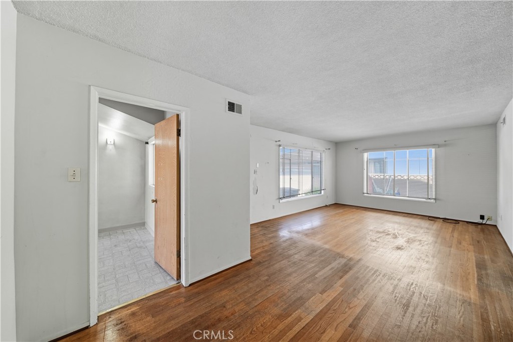 16402 Gridley Road Norwalk, CA 90650 - Photo 11 of 19 a view of empty room with wooden floor and window