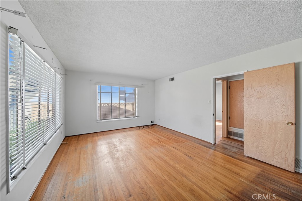 16402 Gridley Road Norwalk, CA 90650 - Photo 13 of 19 a view of an empty room with wooden floor and a window