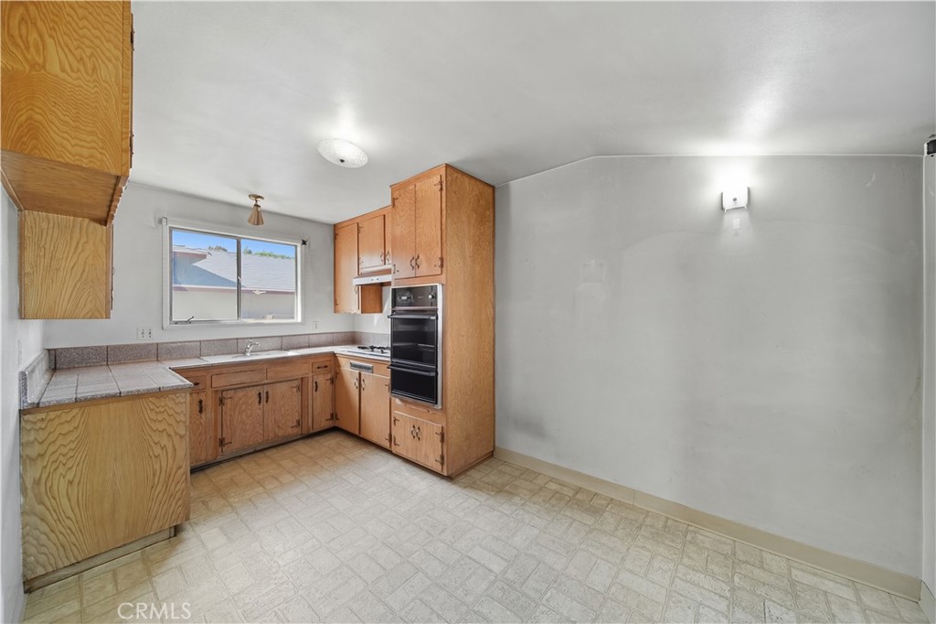 16402 Gridley Road Norwalk, CA 90650 - Photo 7 of 19 a kitchen with granite countertop a refrigerator and a sink