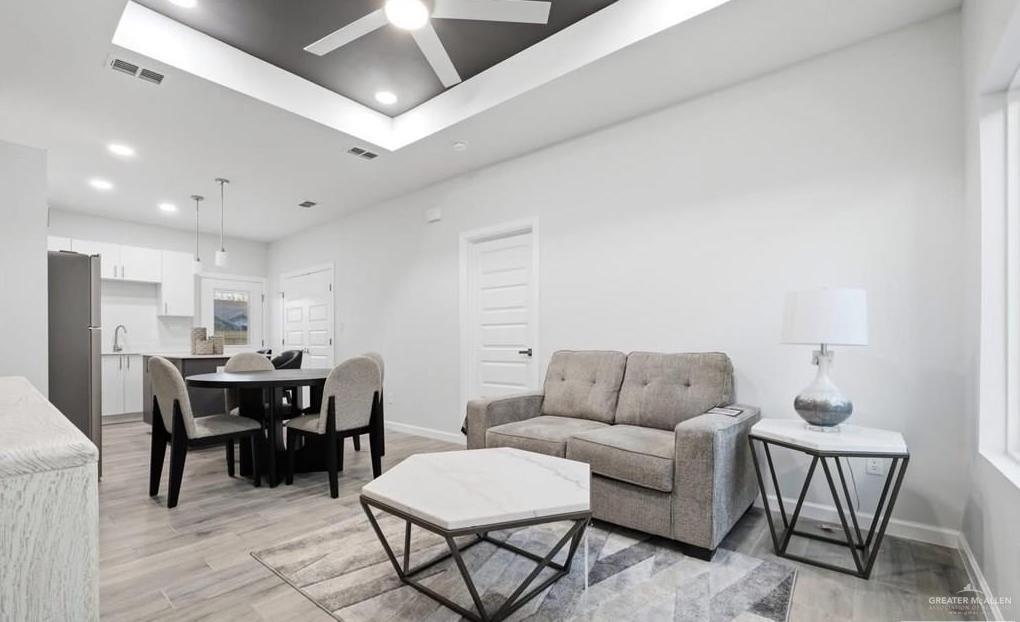 1604 Clinton Street, Unit 2 Harlingen, TX 78550 - Photo 4 of 14 Open-concept living space featuring wood-finish flooring, recessed lighting, and a tray ceiling with a ceiling fan