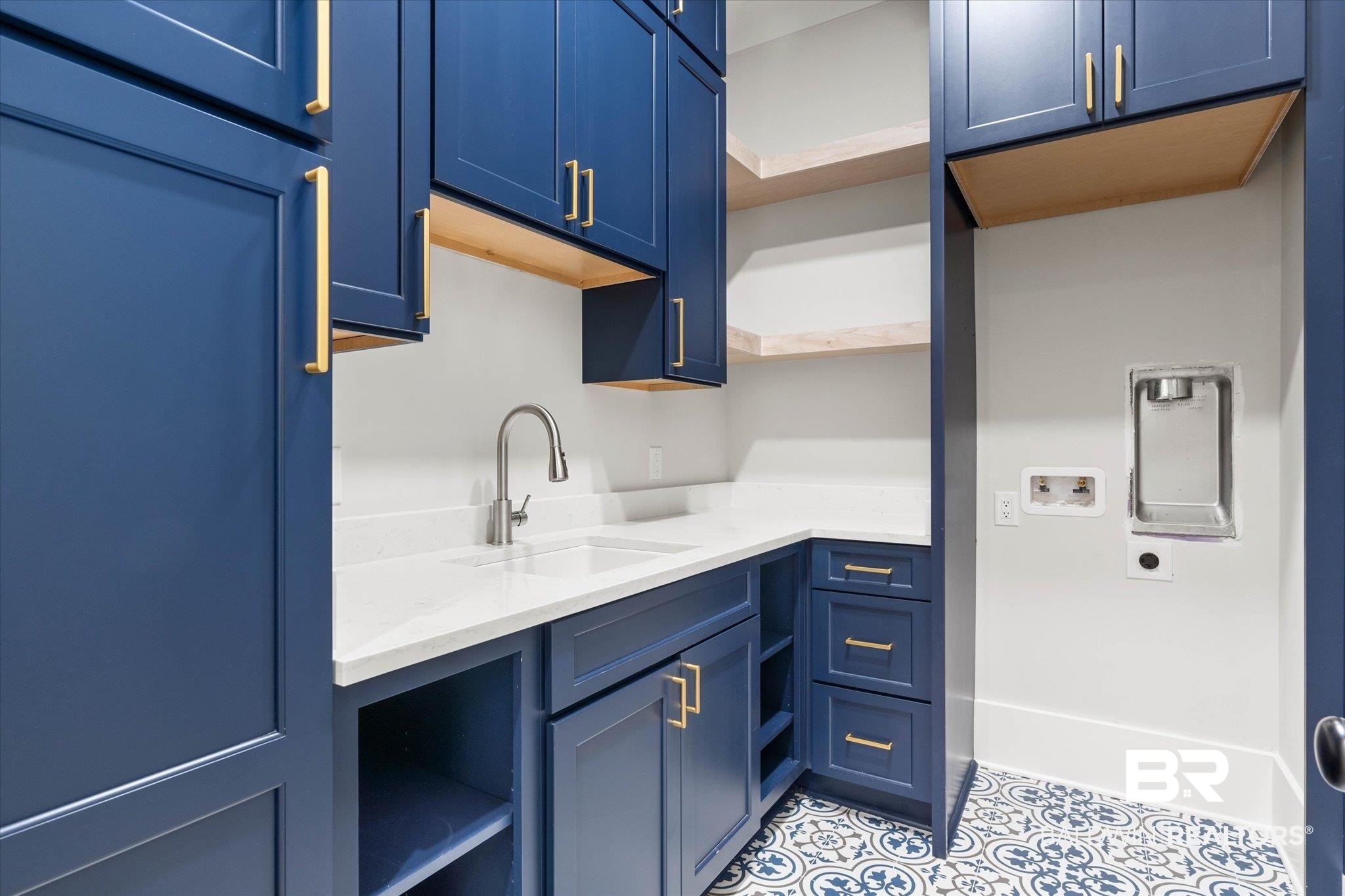 853 Inlet Circle Gulf Shores, AL 36542 - Photo 15 of 55 Kitchen with a sink, light tile patterned floors, open shelves, and blue cabinetry