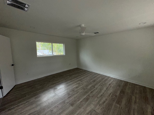 2101 Vanderbilt Lane Austin, TX 78723 - Photo 6 of 11 Unfurnished room featuring dark wood-style flooring and a textured ceiling