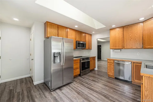 a kitchen with granite countertop a refrigerator stove top oven and sink