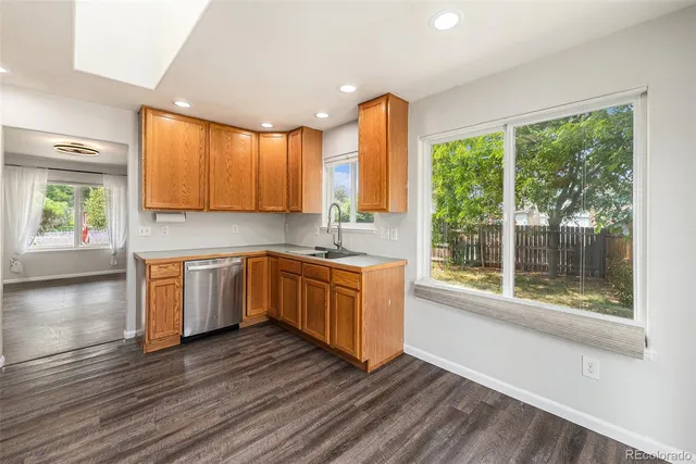 a kitchen with a window wooden floor and a sink