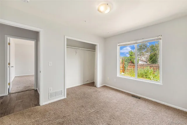 an empty room with windows and closet