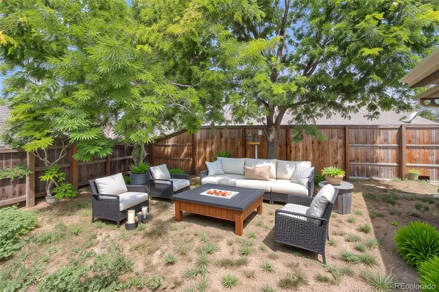 a backyard of a house with fountain table and chairs