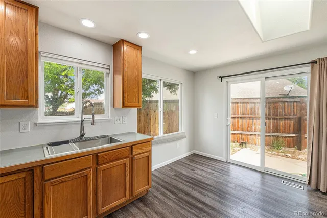 a kitchen with stainless steel appliances granite countertop wooden floors a stove a sink and a window