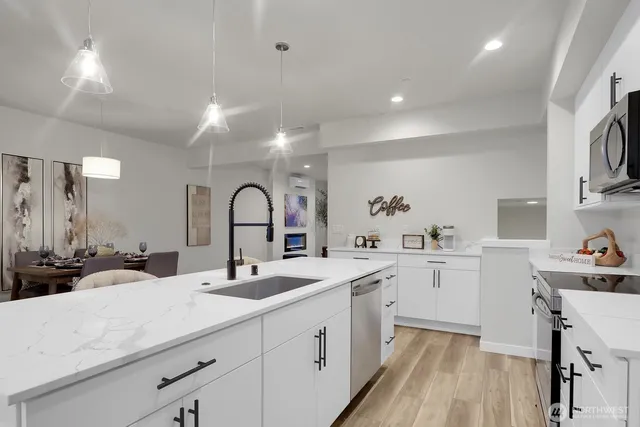 a kitchen with a sink cabinets and wooden floor