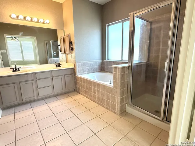a bathroom with a tub a sink and a mirror