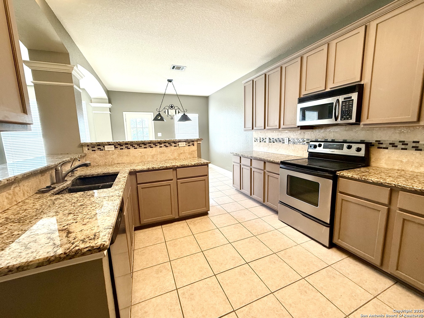 3526 Blackstone Run San Antonio, TX 78259 - Photo 5 of 18 a kitchen with stainless steel appliances granite countertop a stove sink and cabinets