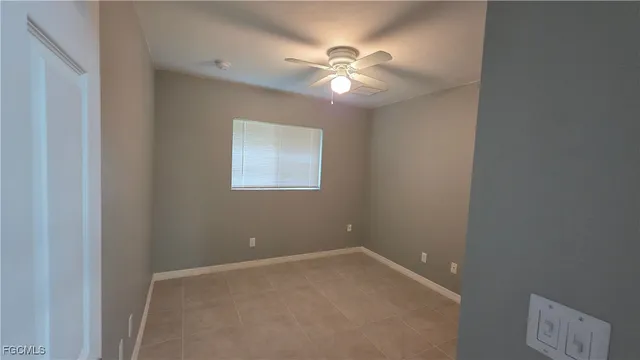 a view of an empty room with a chandelier fan