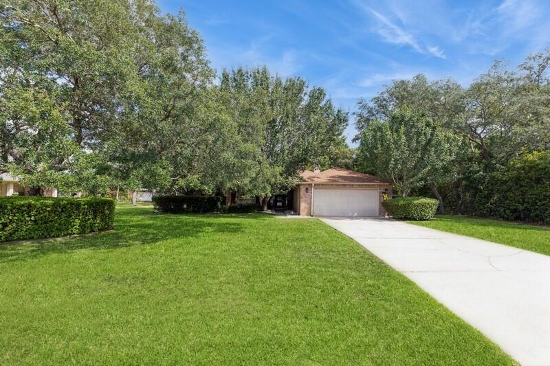 a view of a house with a yard and a tree