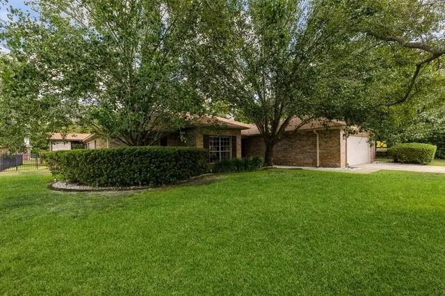 a view of a house with a yard and tree