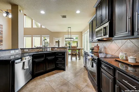 a kitchen with stainless steel appliances granite countertop a stove a sink and a microwave