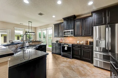 a kitchen with stainless steel appliances granite countertop a sink stove and refrigerator