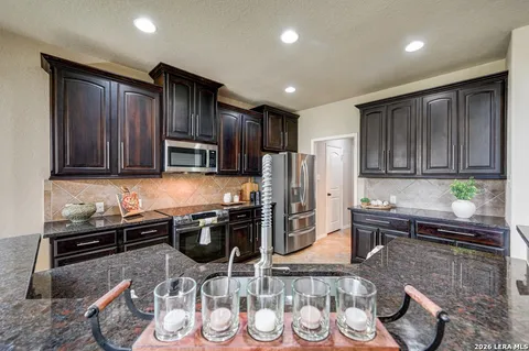 a kitchen with stainless steel appliances granite countertop a sink stove and cabinets