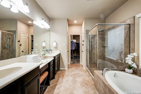a large bathroom with a tub sink shower and mirror