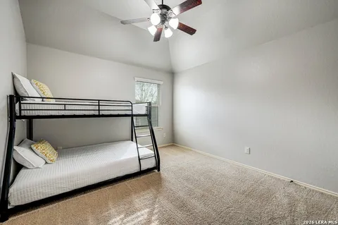 a bedroom with a bed and a chandelier fan