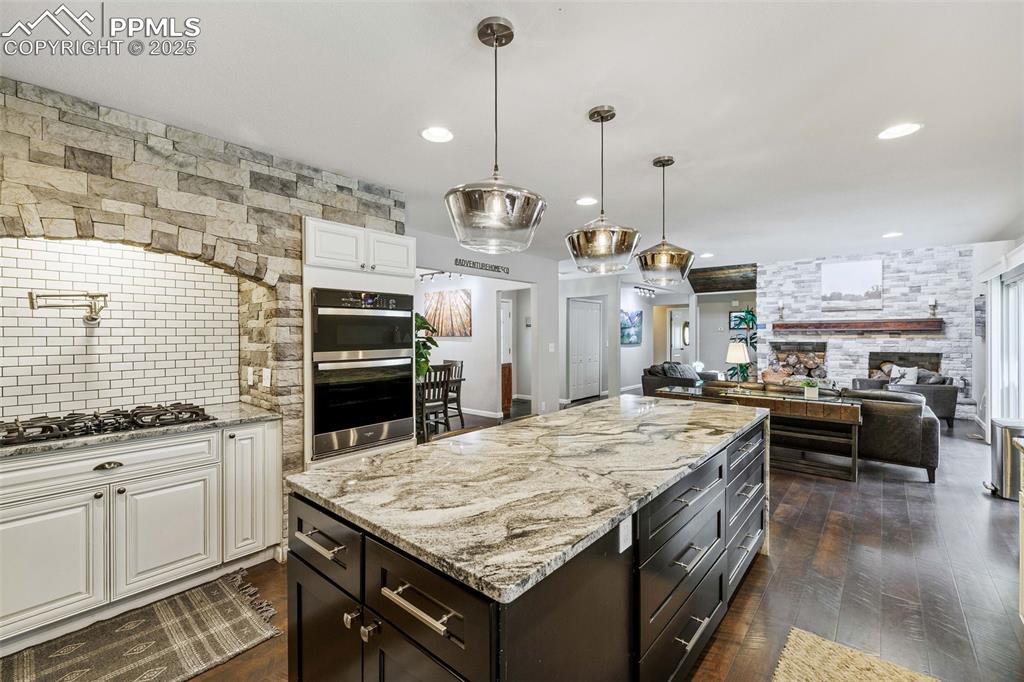 6940 Franciville Road Colorado Springs, CO 80908 - Photo 11 of 40 a kitchen with a stove and a wooden floor