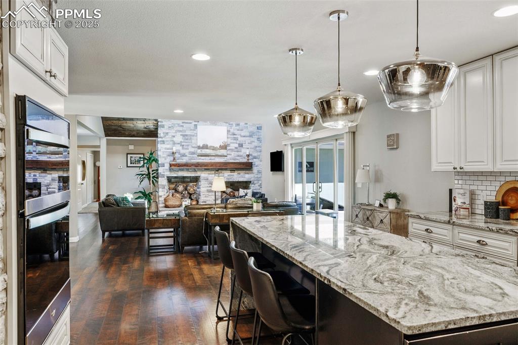 6940 Franciville Road Colorado Springs, CO 80908 - Photo 13 of 40 a kitchen with stainless steel appliances granite countertop a sink a stove and a wooden floor