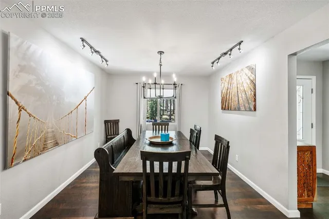a dining room with furniture a chandelier and wooden floor