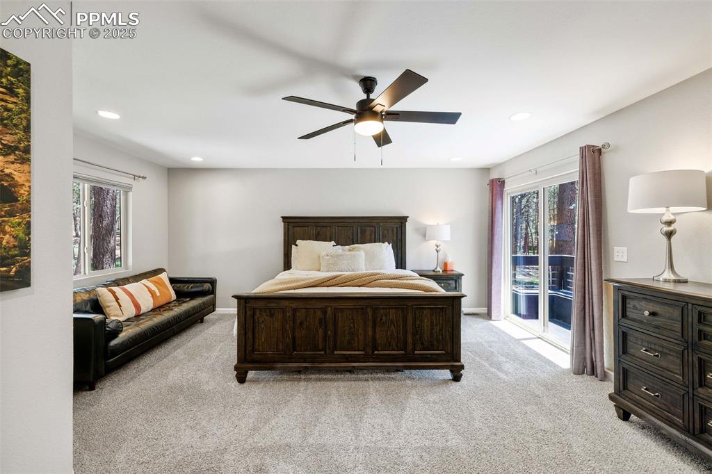 6940 Franciville Road Colorado Springs, CO 80908 - Photo 17 of 40 a spacious bedroom with a bed a dresser and a chandelier