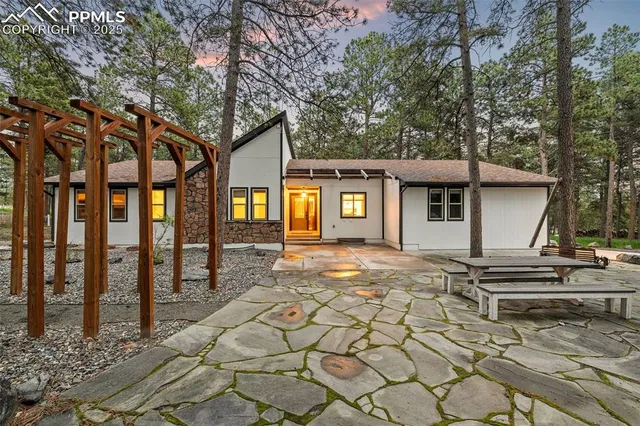 a view of a house with a tree and wooden fence