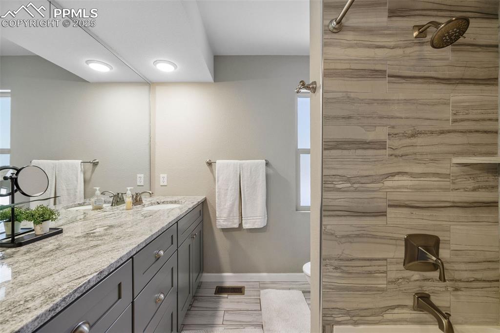 6940 Franciville Road Colorado Springs, CO 80908 - Photo 21 of 40 a bathroom with a granite countertop sink and a mirror