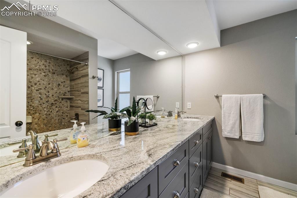 6940 Franciville Road Colorado Springs, CO 80908 - Photo 22 of 40 a bathroom with double vanity and a mirror