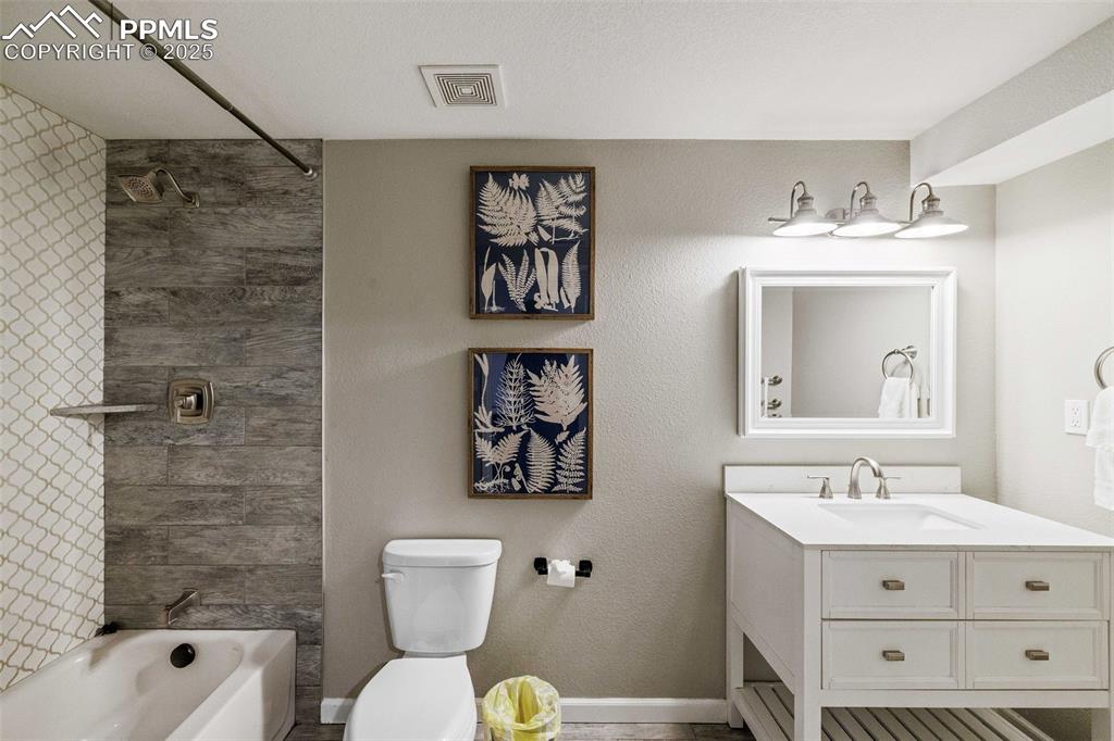 6940 Franciville Road Colorado Springs, CO 80908 - Photo 26 of 40 a bathroom with a sink mirror vanity and toilet