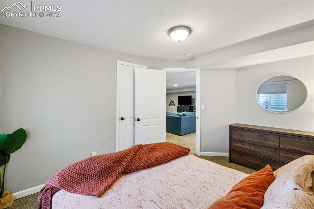 6940 Franciville Road Colorado Springs, CO 80908 - Photo 31 of 40 a bedroom with a bed and a lamp with the wooden floor