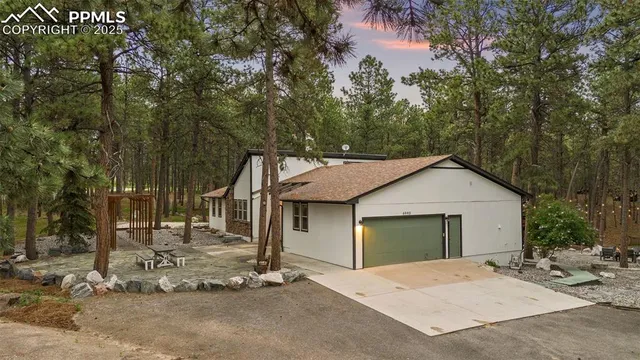 a view of a house with a yard and large tree