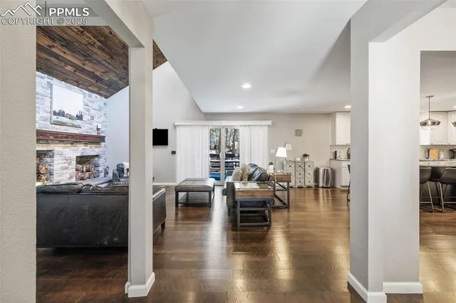 a living room with furniture wooden floor and a large window