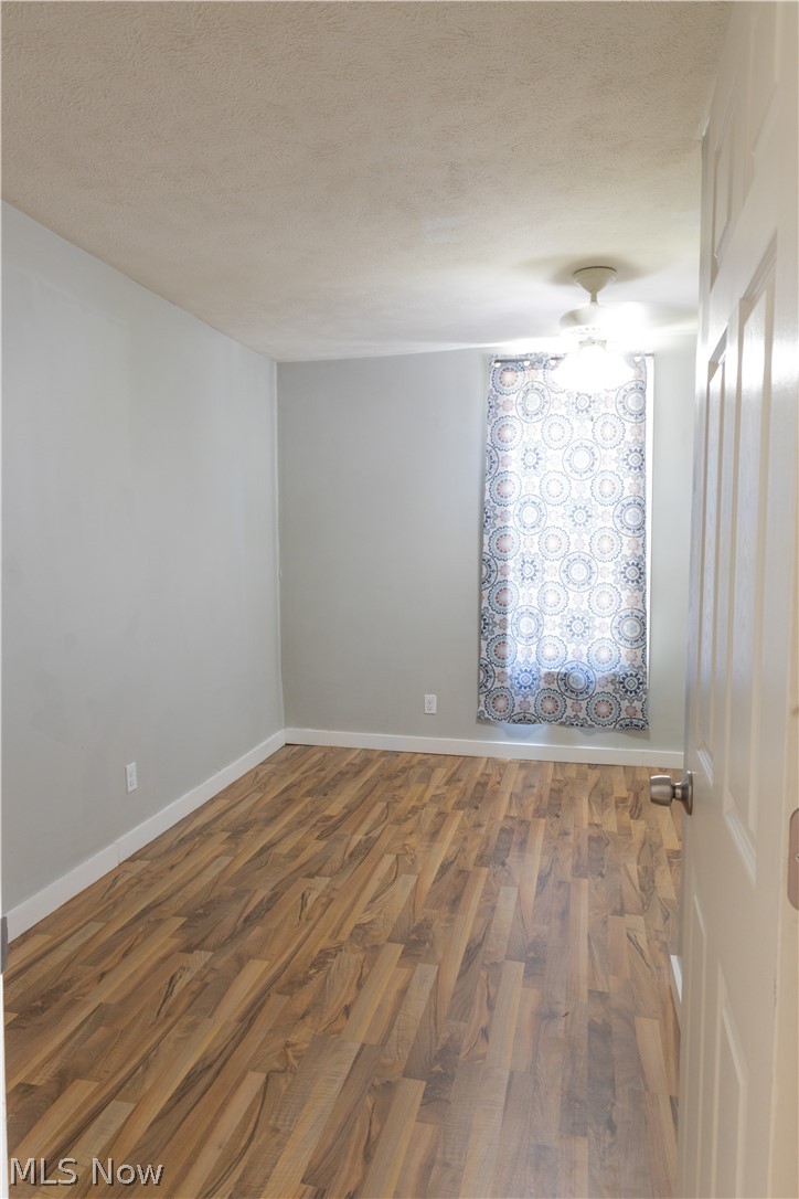180 South Ridge Road West Geneva, OH 44041 - Photo 20 of 40 Unfurnished room featuring a textured ceiling and hardwood / wood-style flooring