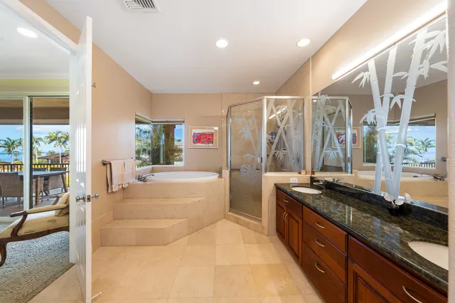 a spacious bathroom with a granite countertop sink a large mirror and a bathtub