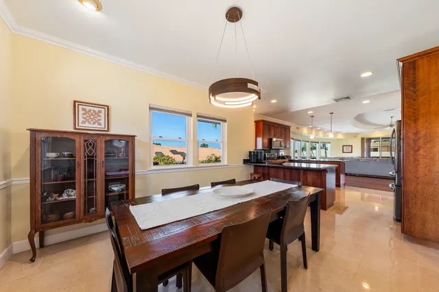 a dining room with stainless steel appliances kitchen island a table and chairs