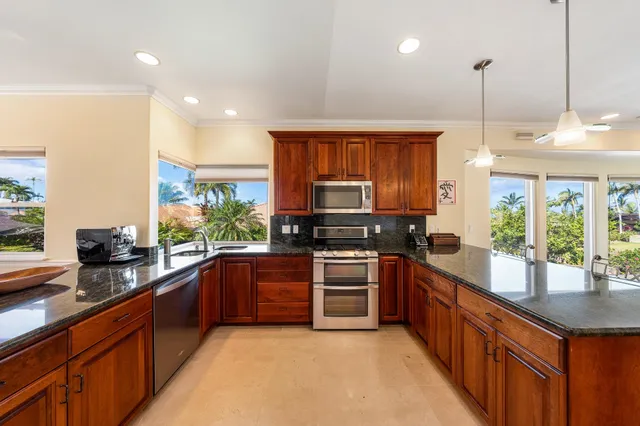 a kitchen with stainless steel appliances granite countertop sink stove and microwave