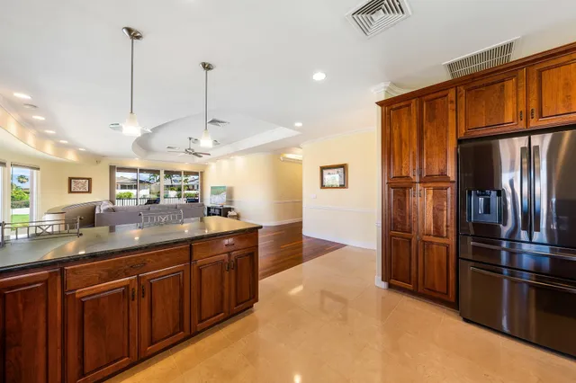 a kitchen with stainless steel appliances granite countertop a refrigerator a sink and a stove