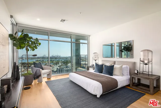 a bedroom with a bed and a large window with balcony view